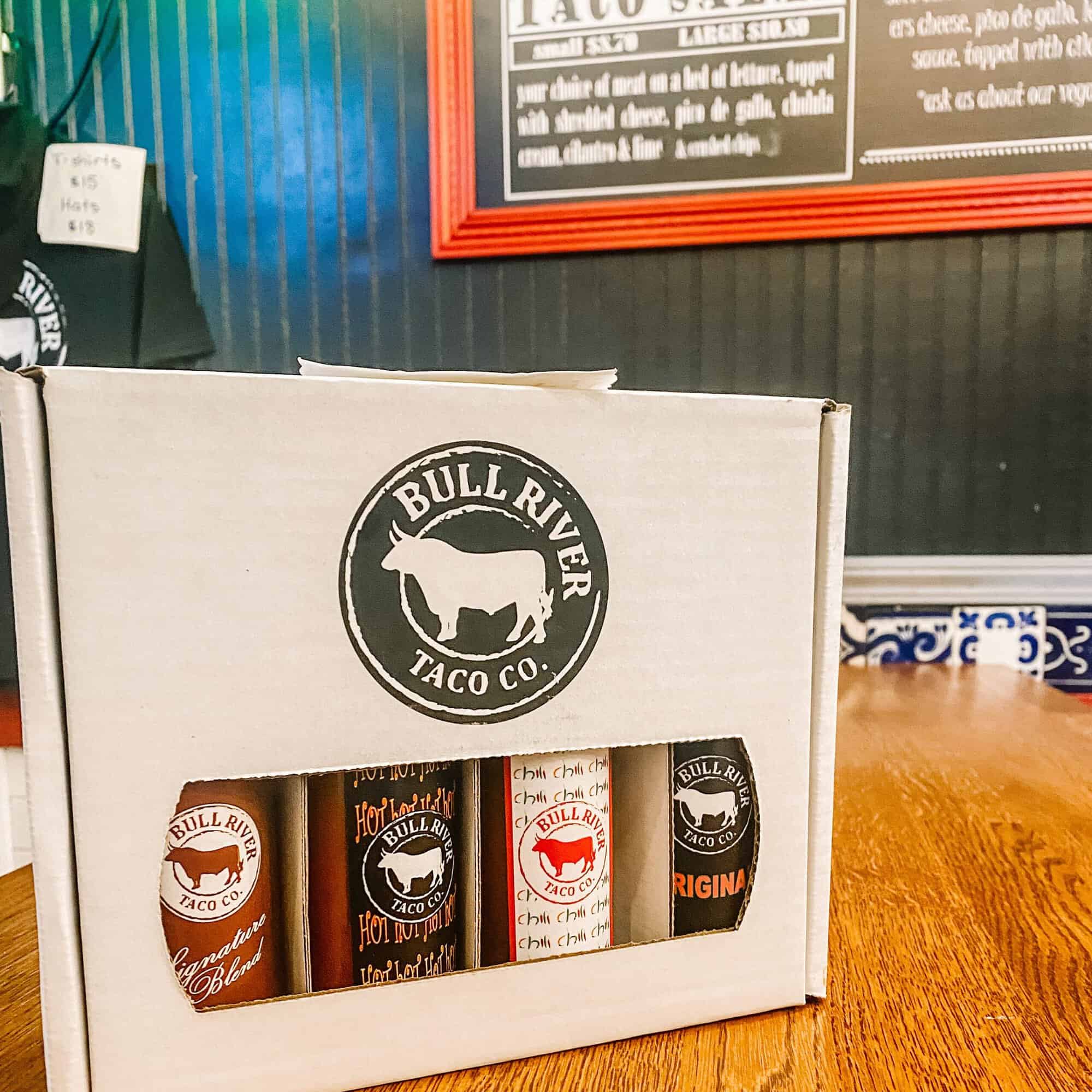 A photo of the bottled and boxed hot sauces at Bull River Taco Co.