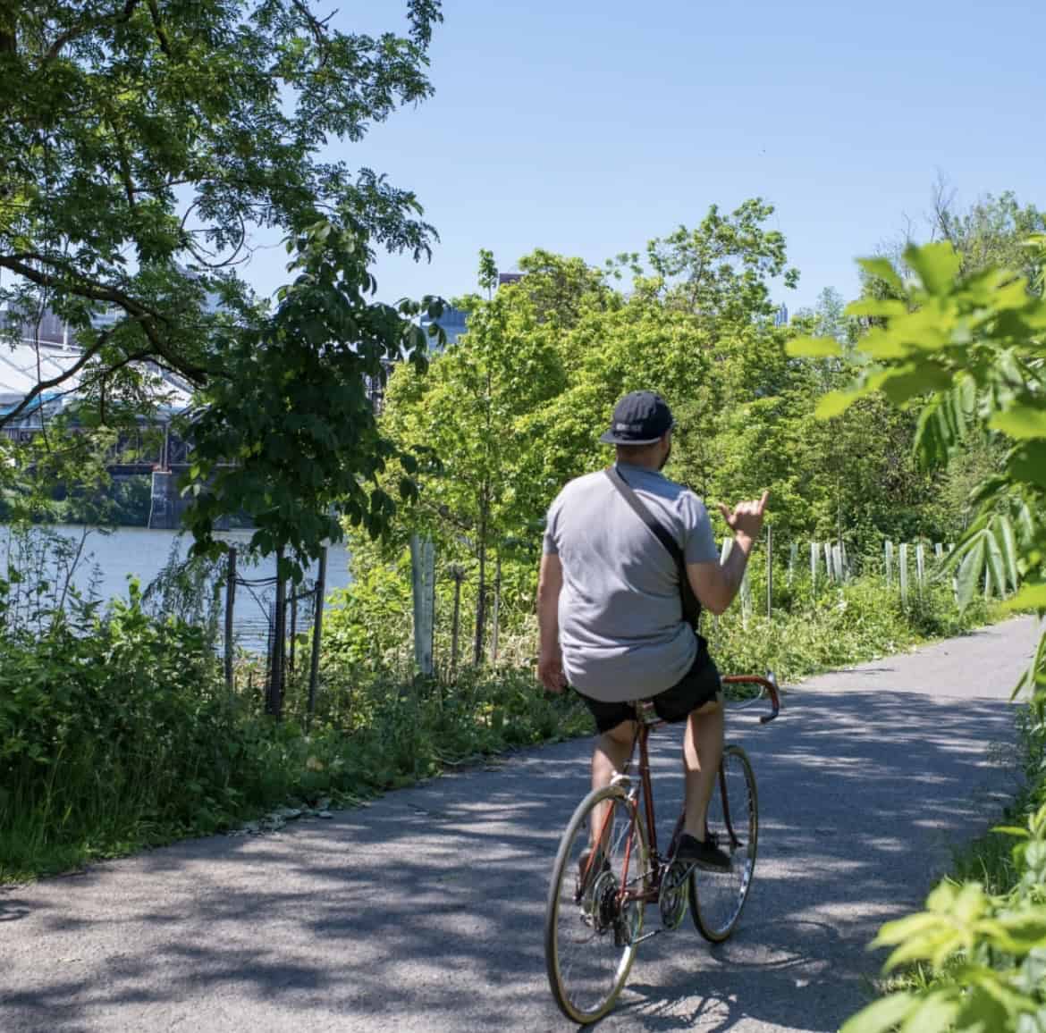 A person riding a bike on a trail along a river