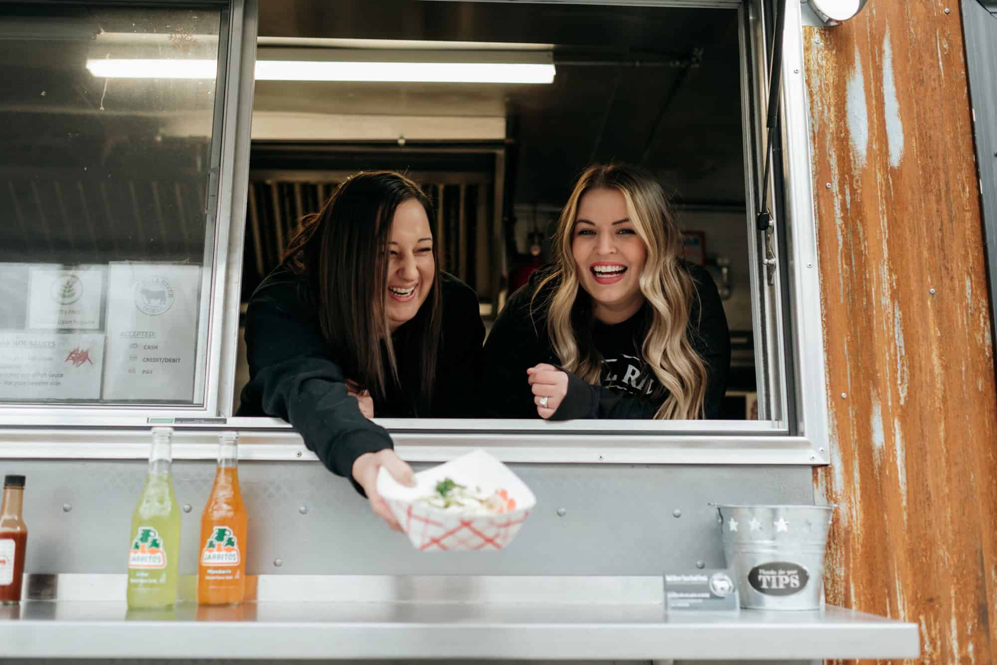 Two women serving food from the food truck