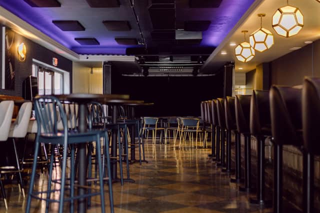A photo of the bar and tables and chairs inside The Bridge Music Bar