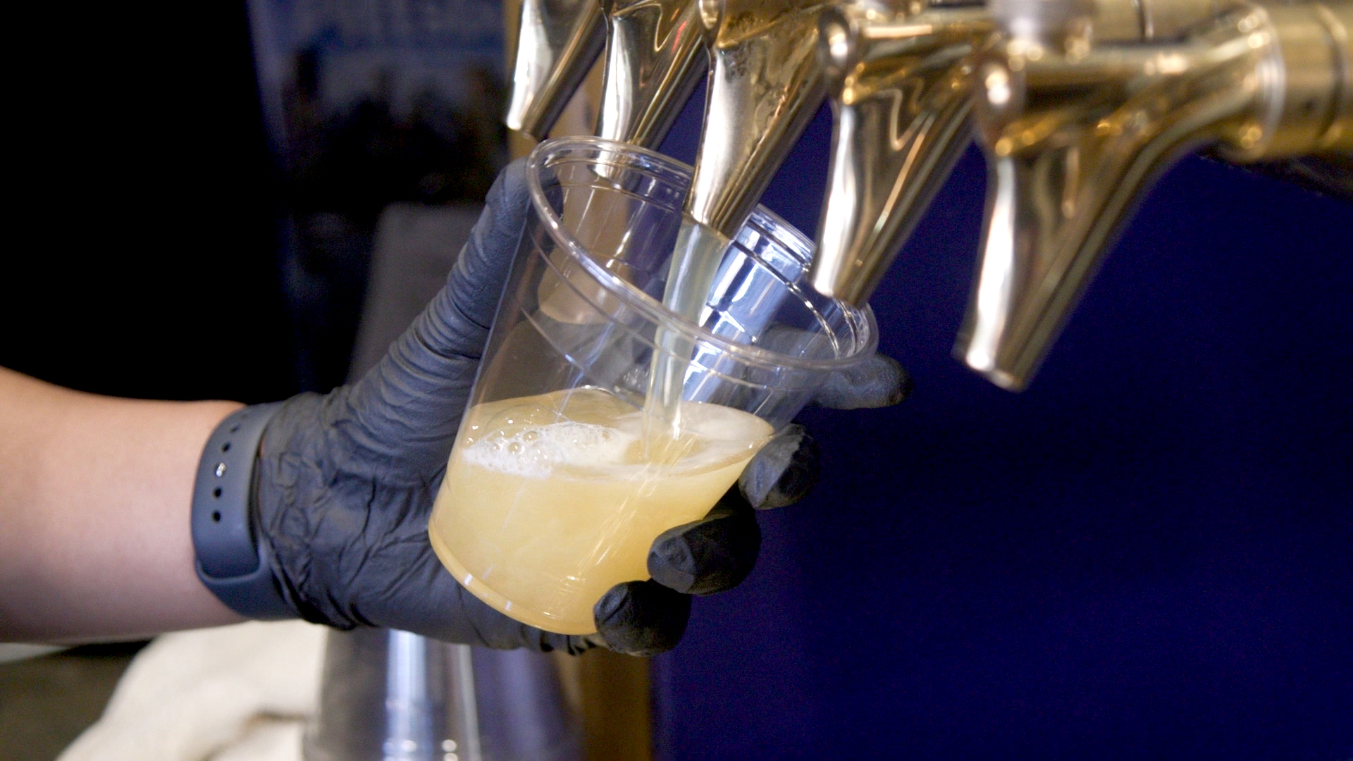A photo of someone pouring a sample of beer into a cup.
