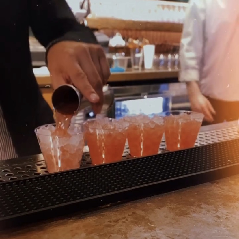 A photo of the bartender pouring four samples of the Kingfly Julip.