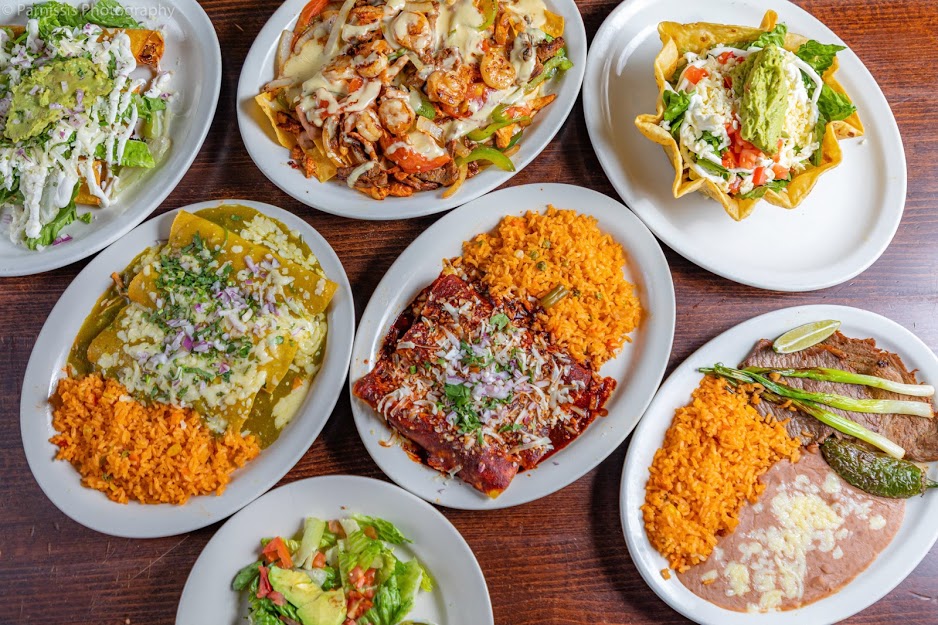 An overhead photo of 7 different dishes at Los Mayas Mexican Restaurant.