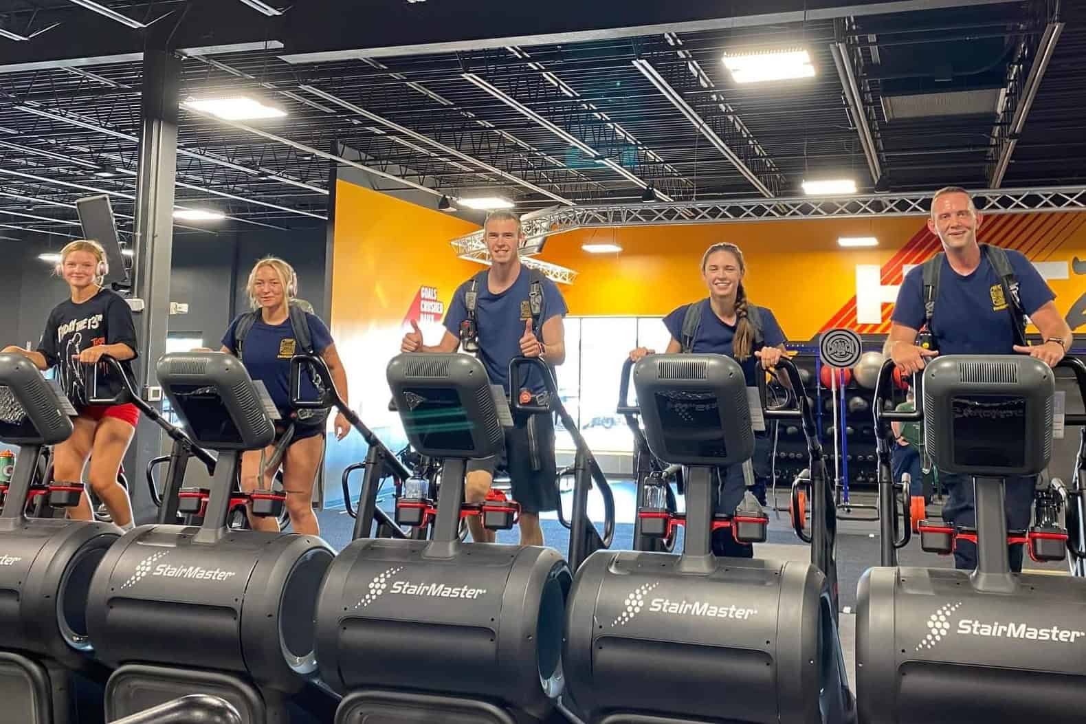 5 people use the StairMaster machines at Crunch Fitness to complete the 9/11 Remembrance Stair Climb challenge.