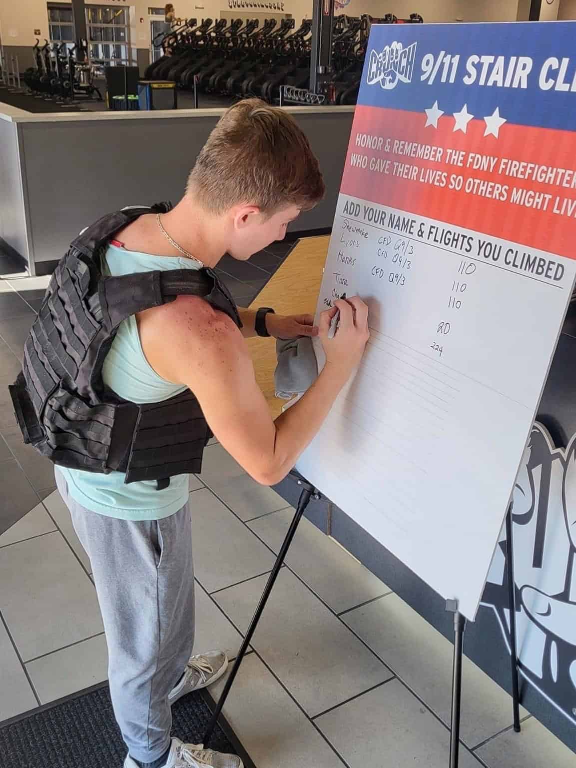 A person writes their name on the 9/11 Stair Climb board to keep track of how many flights of stairs people climbed.