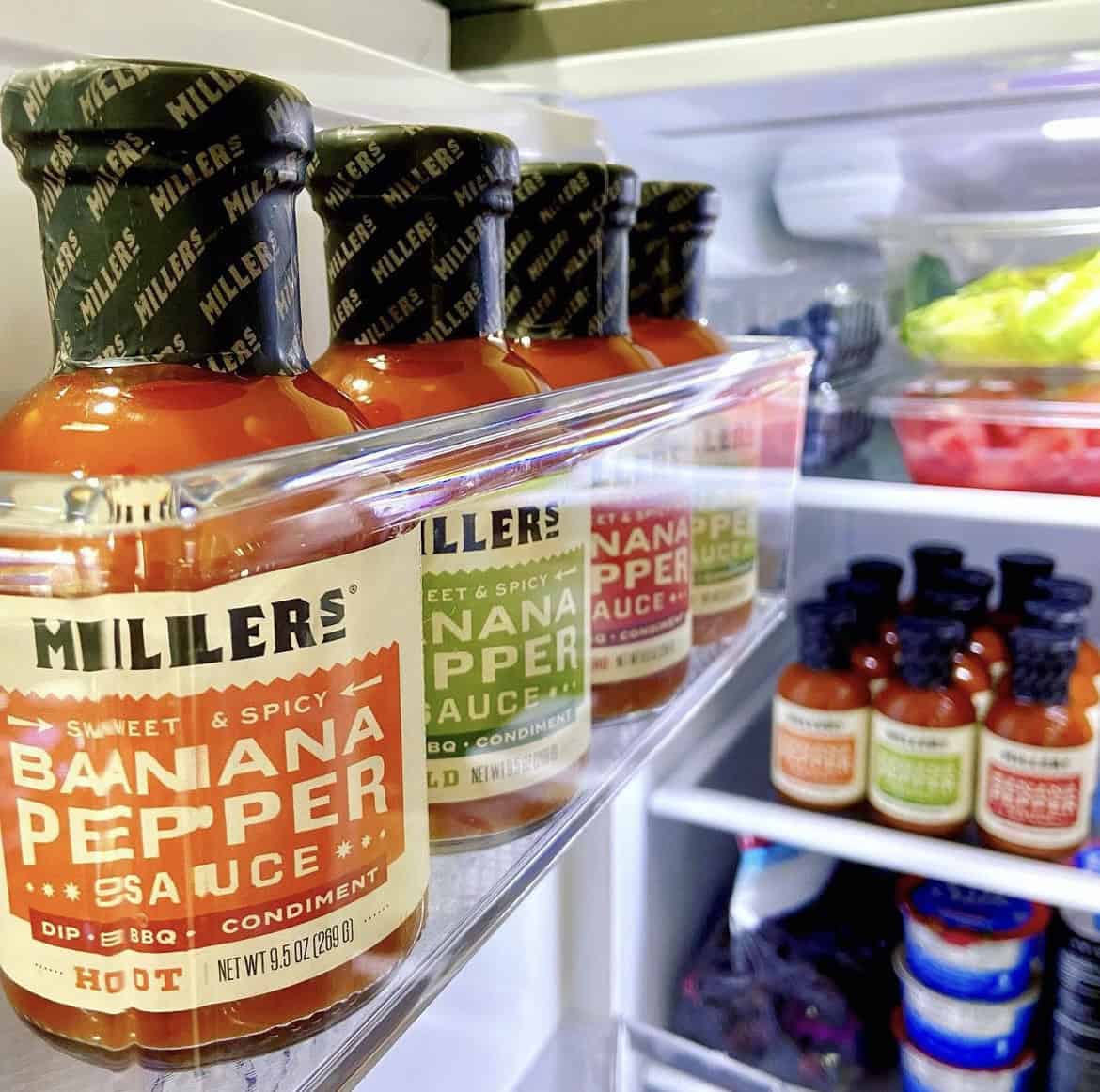 A photo of a fridge full of Miller's Banana Pepper Sauce.