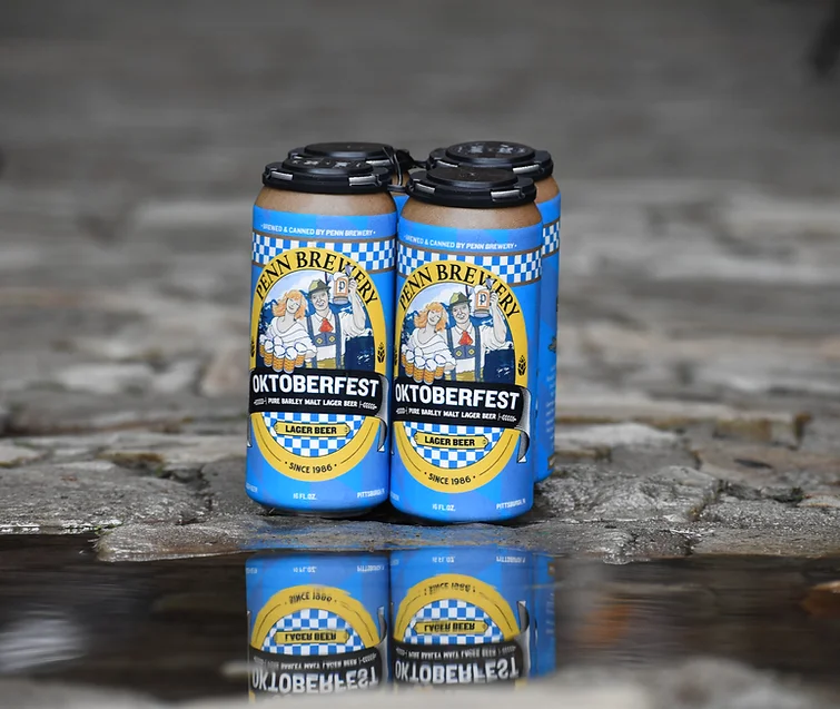 A photo of Penn Brewery's Oktoberfest cans reflecting off of water.