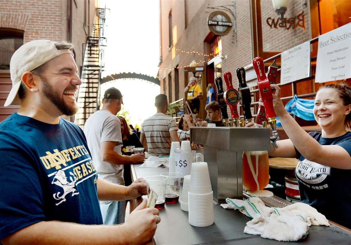 A photo of someone laughing while being served at a bar at Oktoberfest.