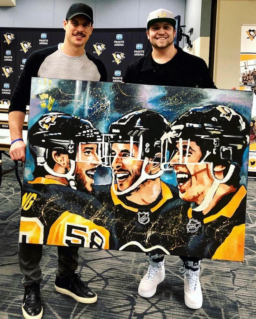 A photo of artist Cody Sabol, who will be at the Great Yinzer Tailgate on November 4th, 2023. with Sidney Crosby and his painting of the 3 star Penguins players.