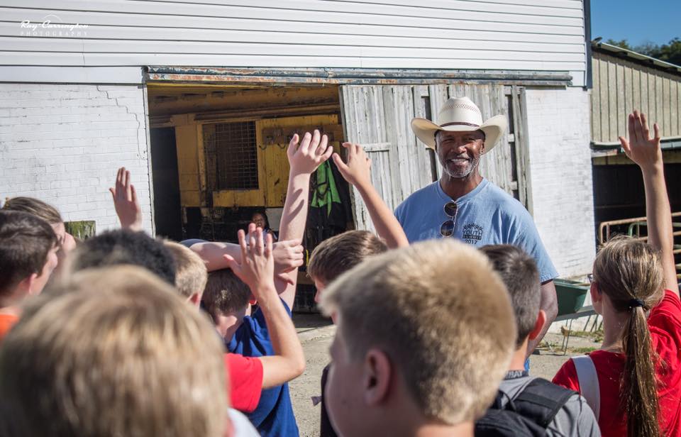 A photo of Mel Blount, who will be at the Great Yinzer Tailgate on November 4th, 2023, at his ranch talking to children in the Mel Blount Youth Leadership Initiative.