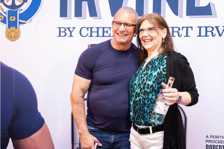 A photo of a woman posing for a photo with Robert Irvine at the Pittsburgh Wine & Spirit Festival.