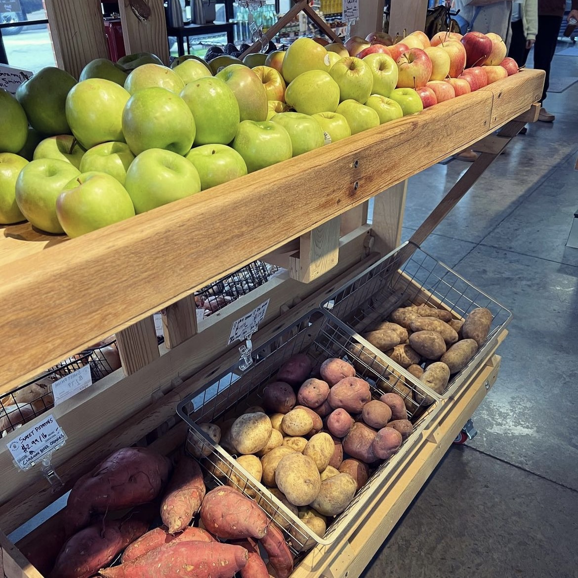 A photo of rows of apples and potatoes available at Millvale Market, a grocery store in Pittsburgh.