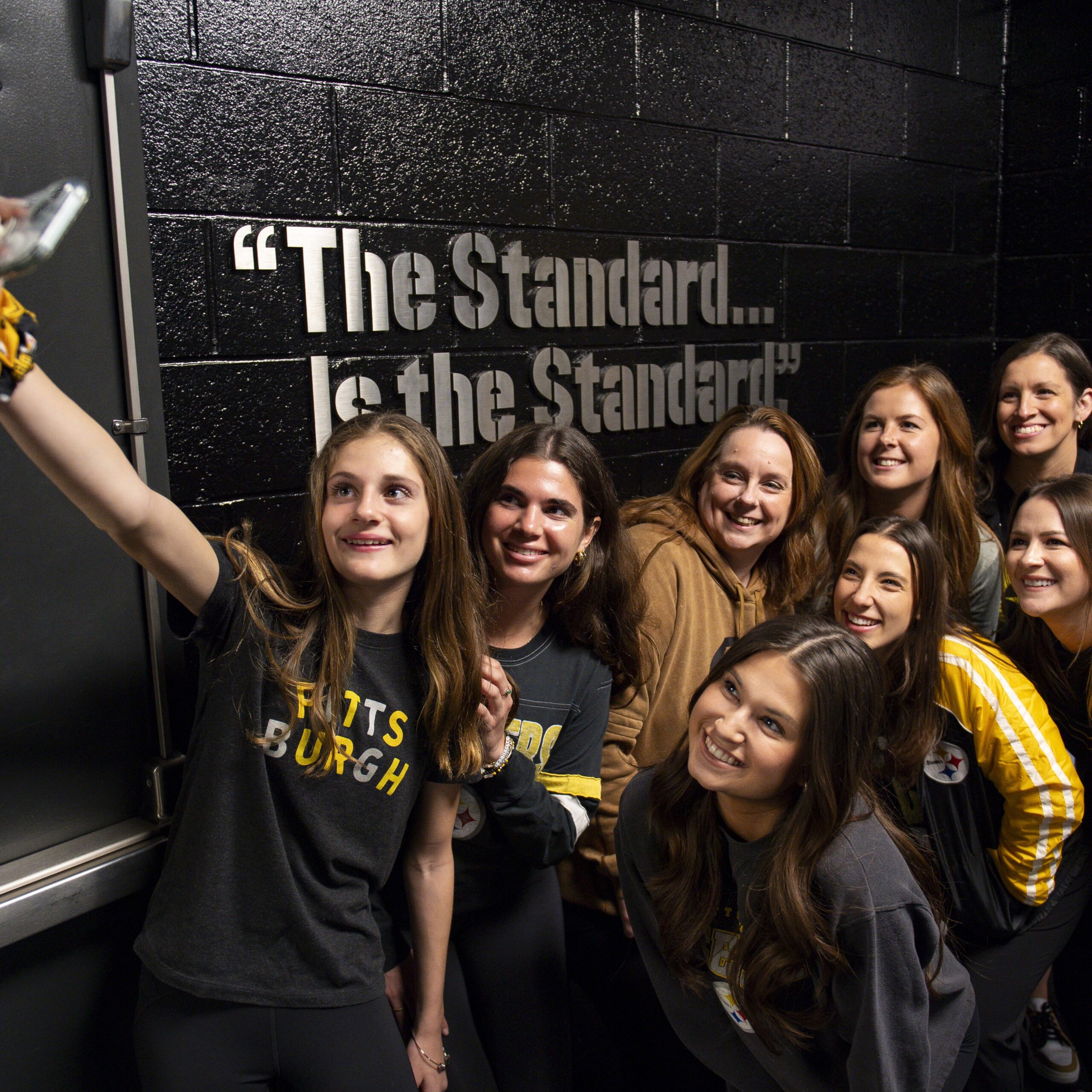 A photo of women posing together for a selfie outside the Steelers locker room.