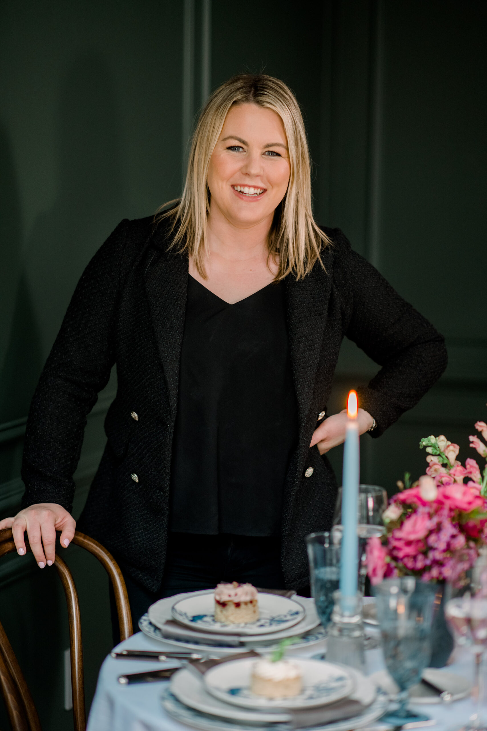 A photo of a wedding planner standing near a table set with dessert.