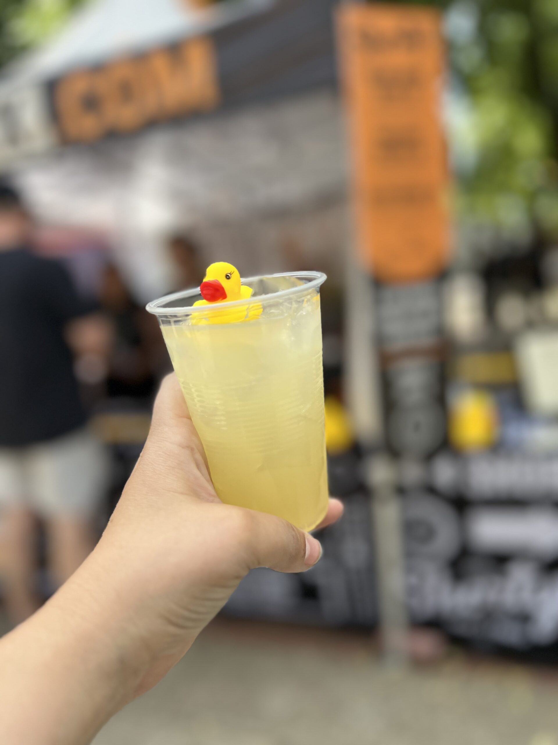 A photo of someone holding a drink with a yellow rubber duck in it.