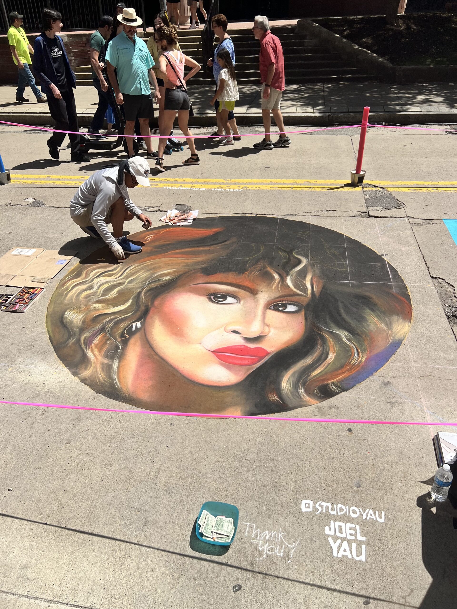 A photo of a chalk artist working on a portrait at Riverlife Chalk Fest.