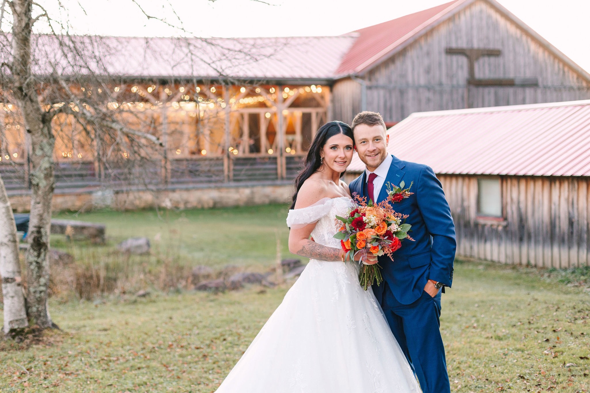 A photo of a bride and groom posing in front of the barn wedding venue at SanaView Farms Winery.