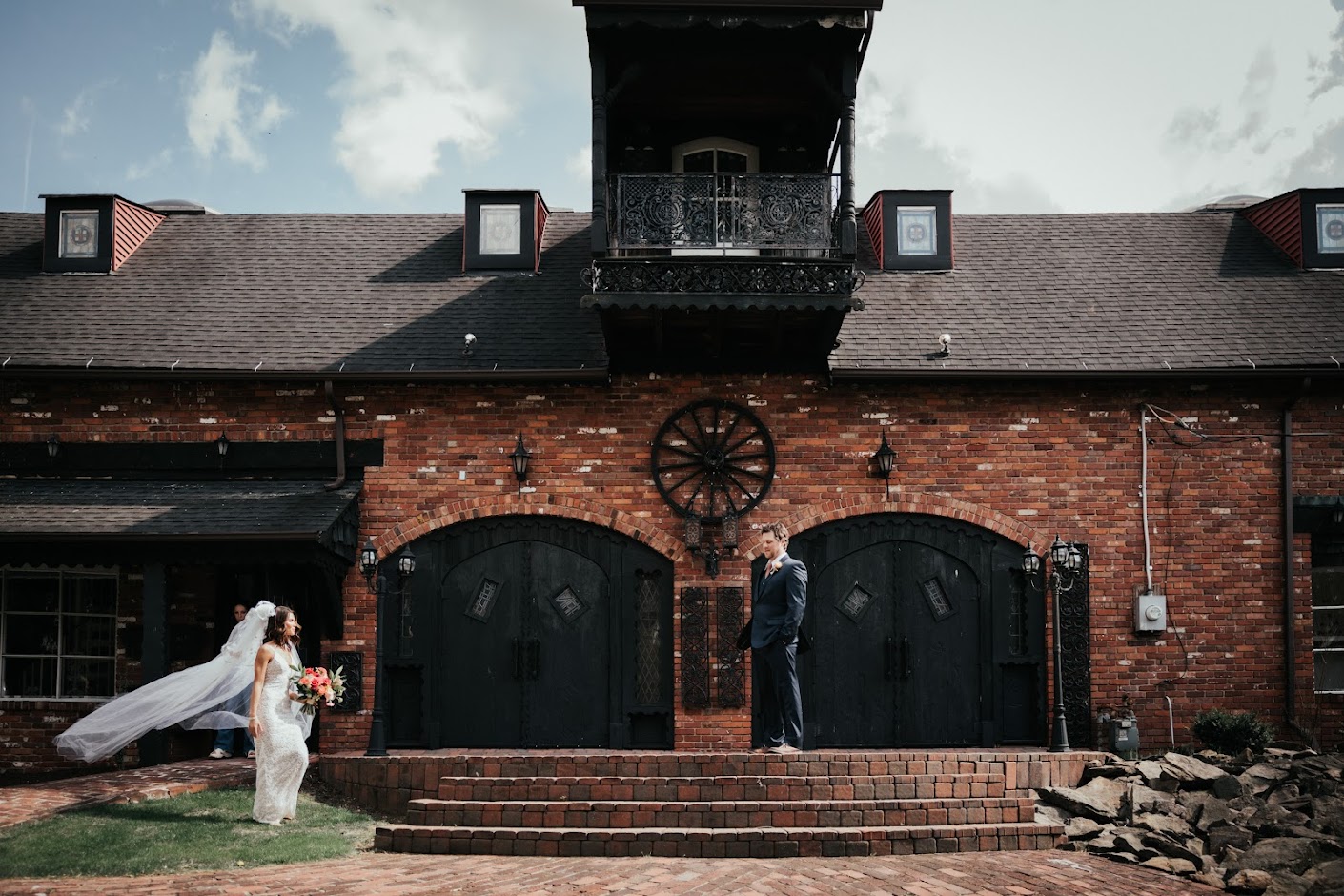 A photo of a groom and bride standing far apart in front of the Barn at Madison wedding venue.
