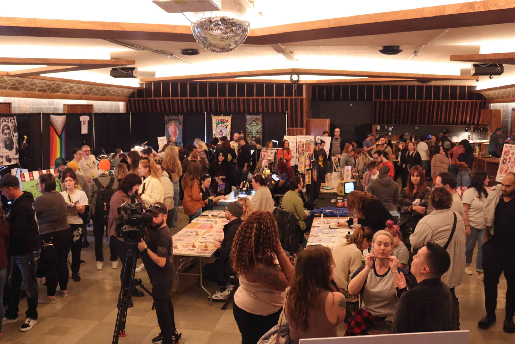 A photo of people walking around and talking at Ink for Impact in 2023.