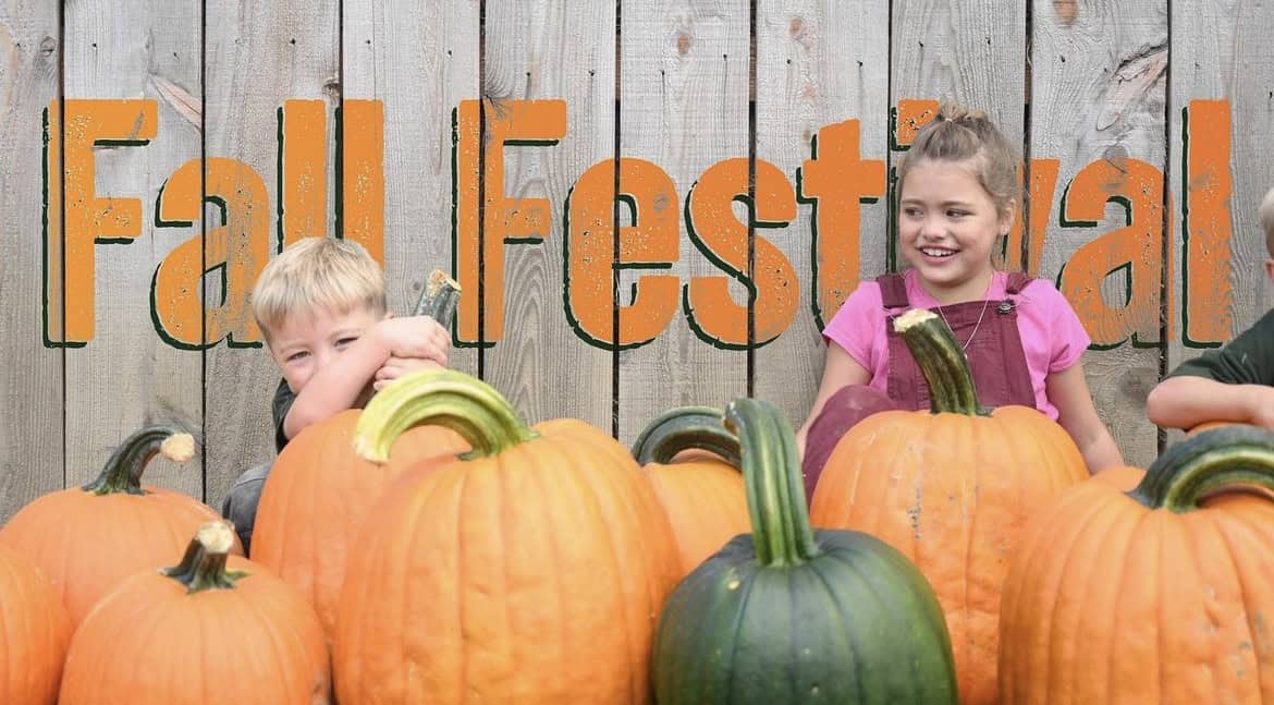 A photo of children hiding behind pumpkins at Freedom Farms' Fall Festival.