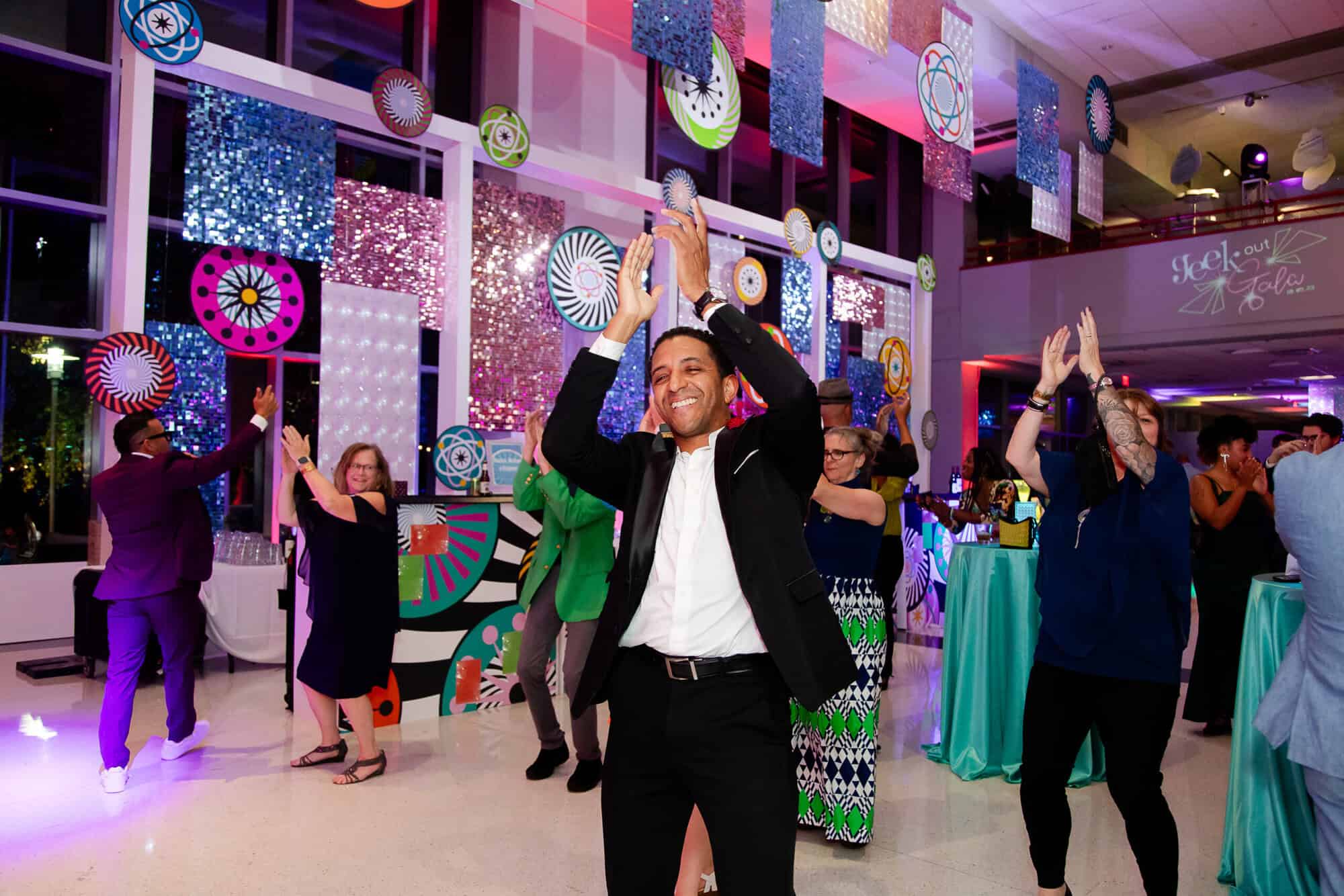 A photo of people clapping and line dancing at the 2023 Geek Out Gala.