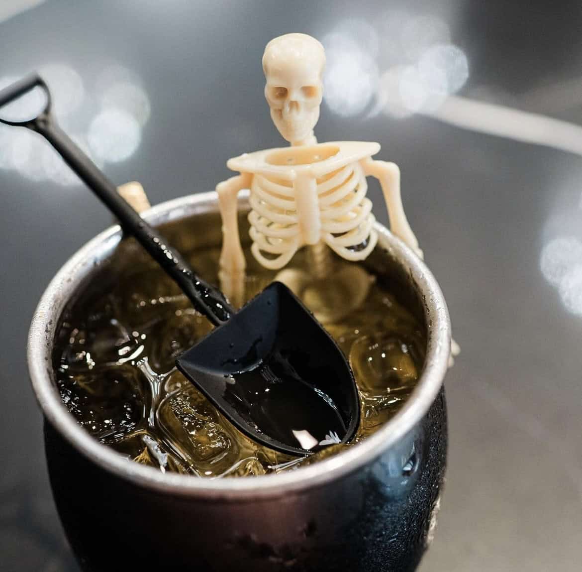 A photo of the Gravedigger cocktail at Ritual House, which features a mini skeleton and shovel in the drink.