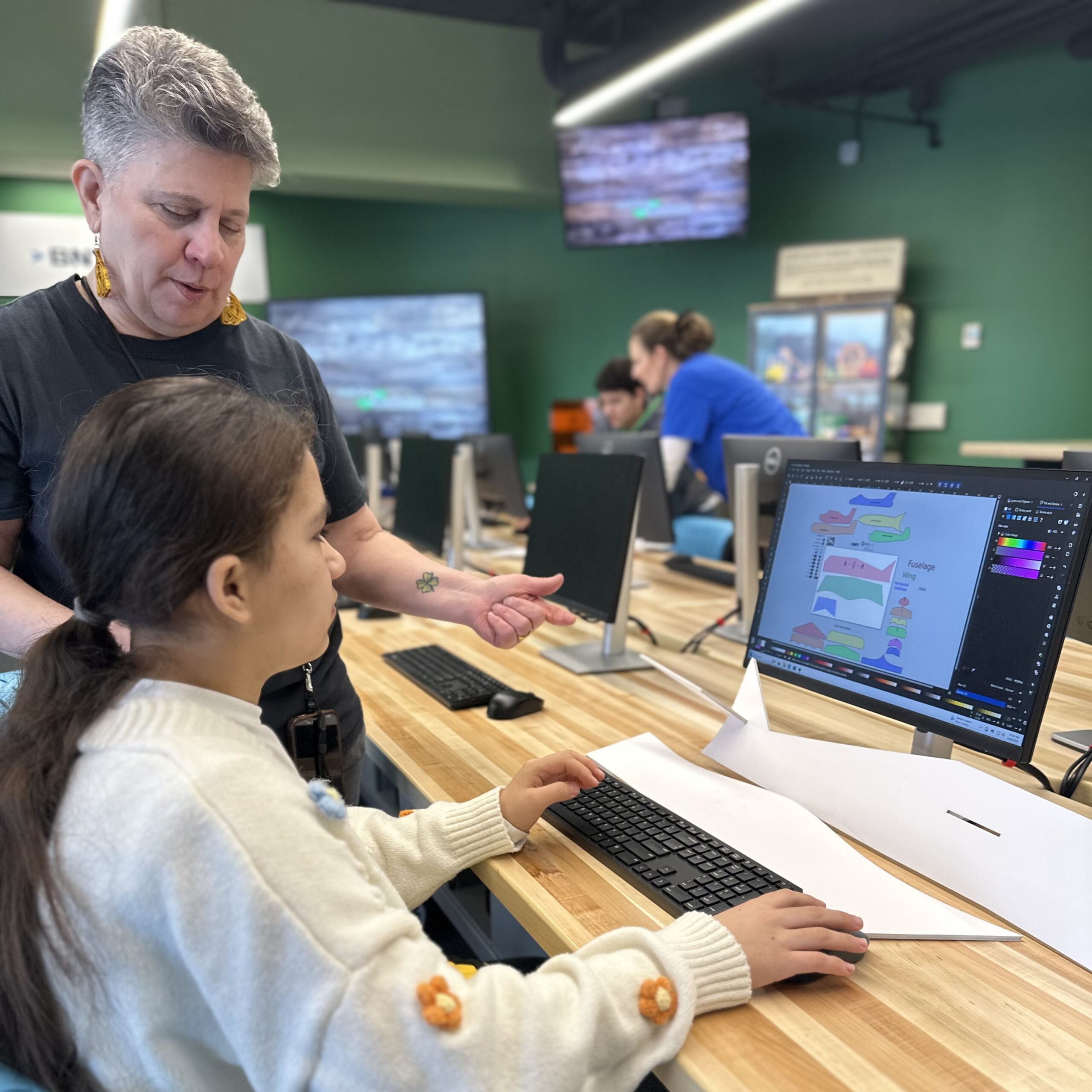 A photo of a child learning  a computer program with an adult.