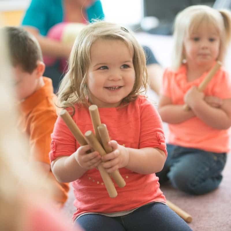 Children holding rhythm sticks.