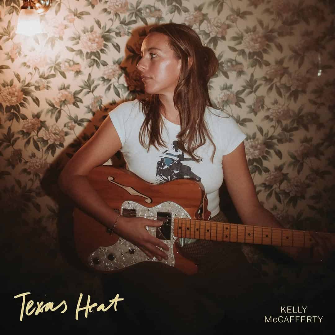 A photo of the Texas Heat album cover featuring Kelly McCafferty looking to the left while holding a guitar.