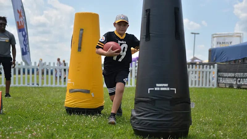 A photo of a child running a football drill at Steelers Training Camp.