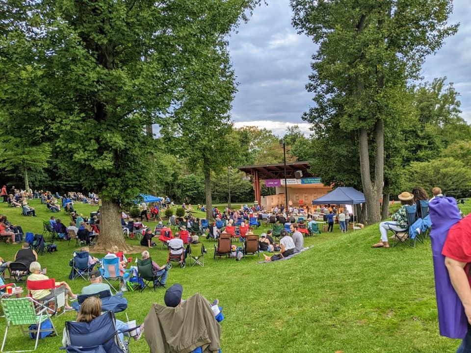 A photo of people in lawn chairs in the park facing the stage at the Monroeville Jazz Festival.