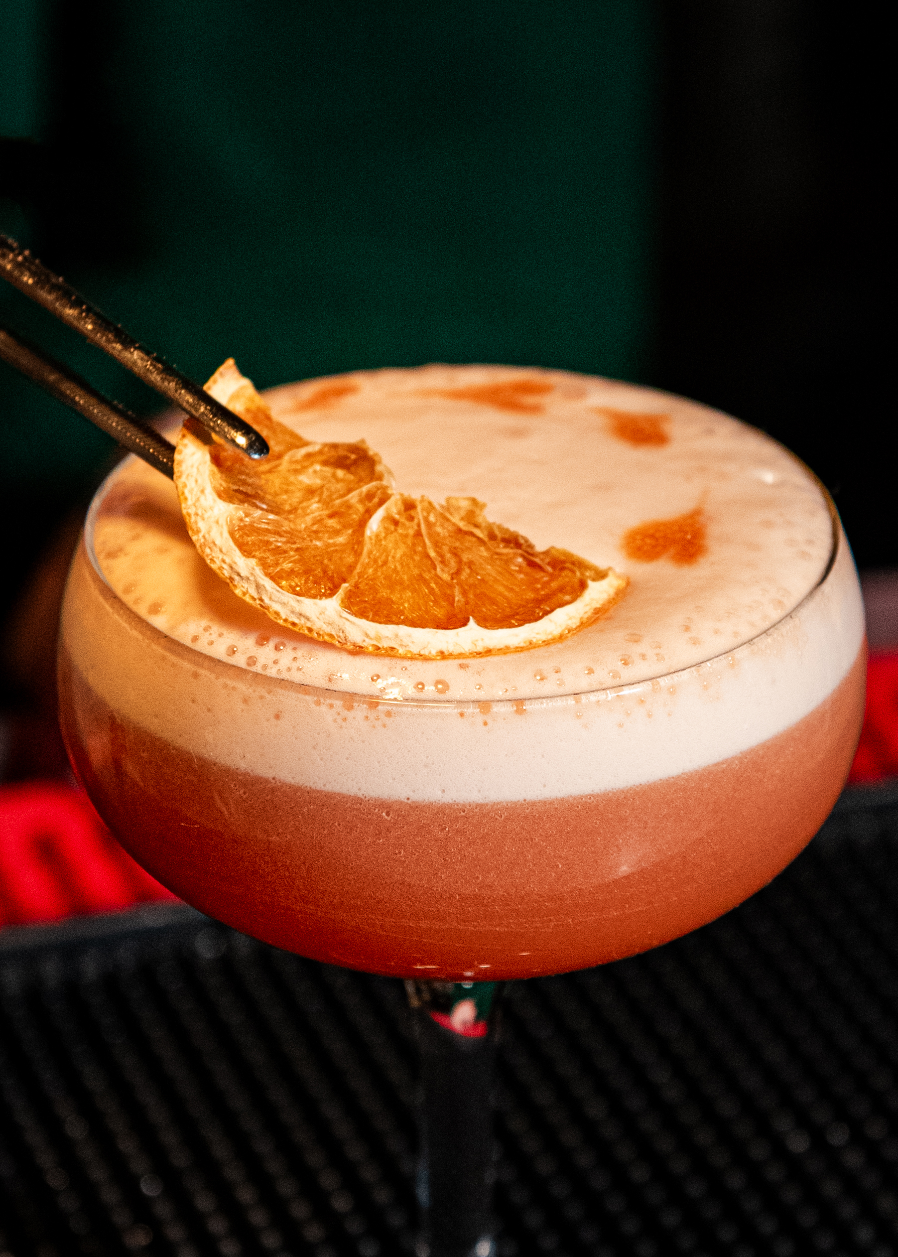 A photo of the Aperitivo Club Dolce & Garibaldi cocktail with a dried orange slice.