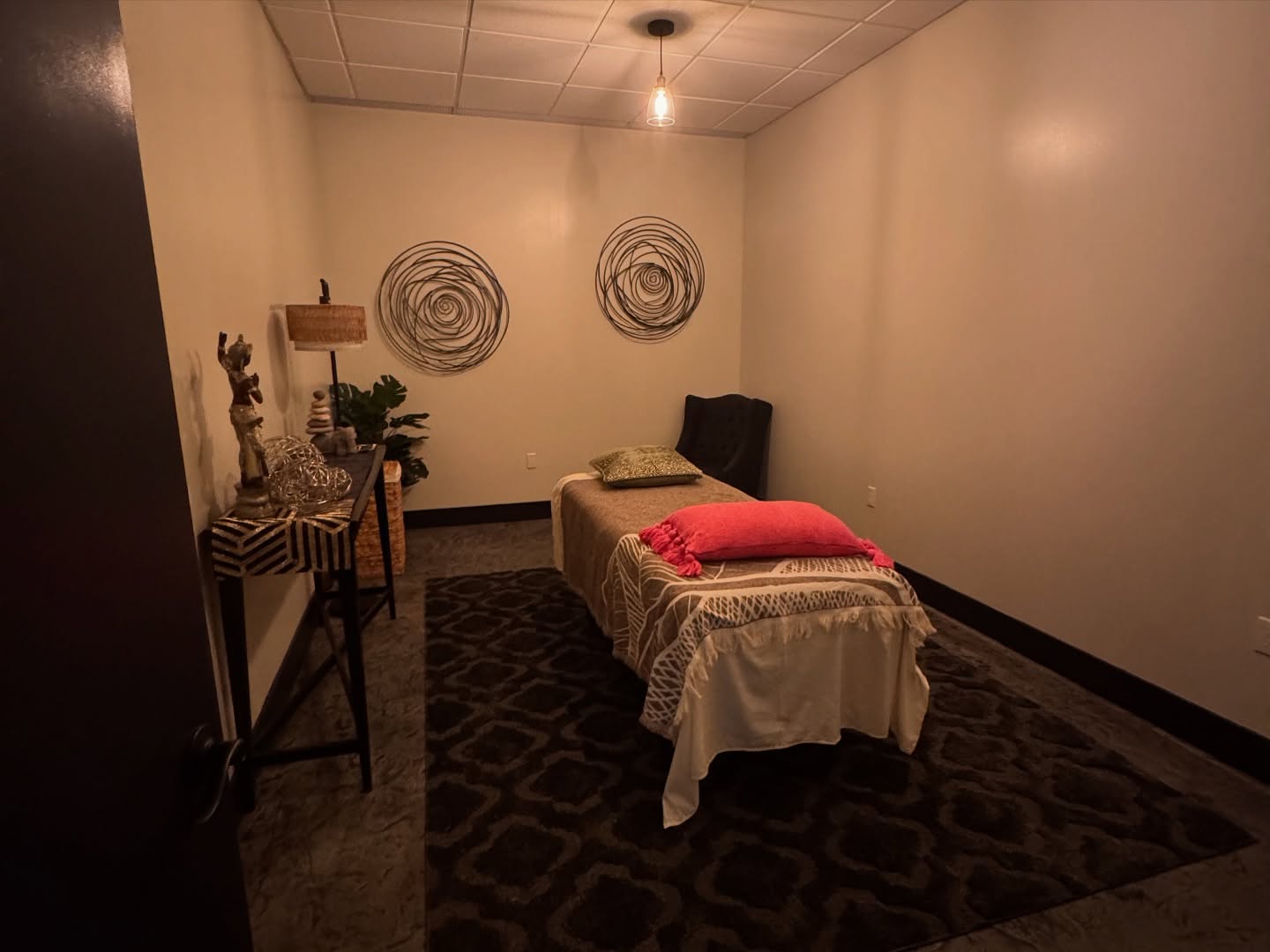 A photo of a massage or reiki table in a warmly lit room at Elements Counseling and Wellness Spa.