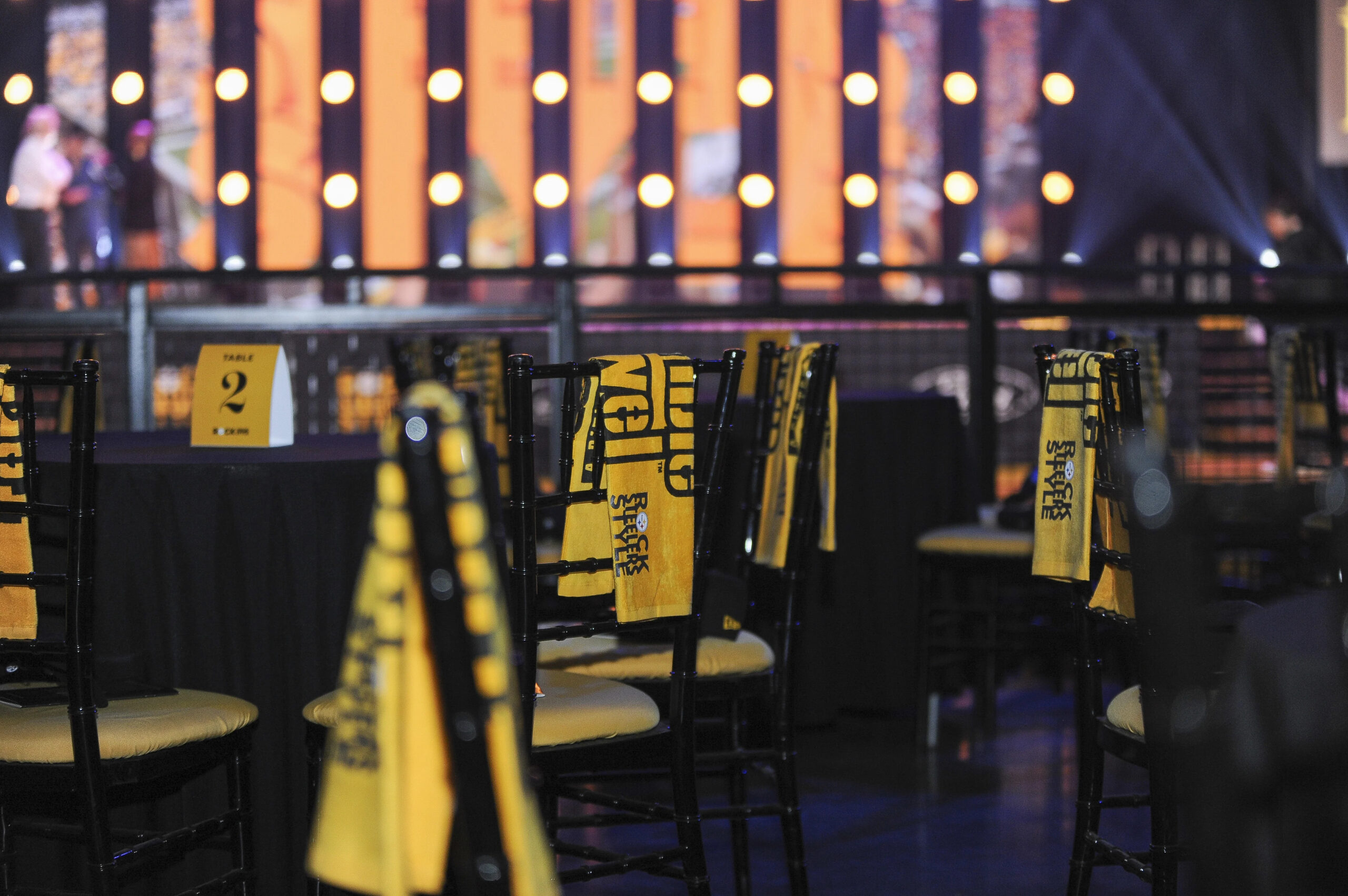 A photo of tables set at Steelers Style with Terrible Towels on each chairback.